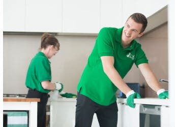 multiple people cleaning a kitchen