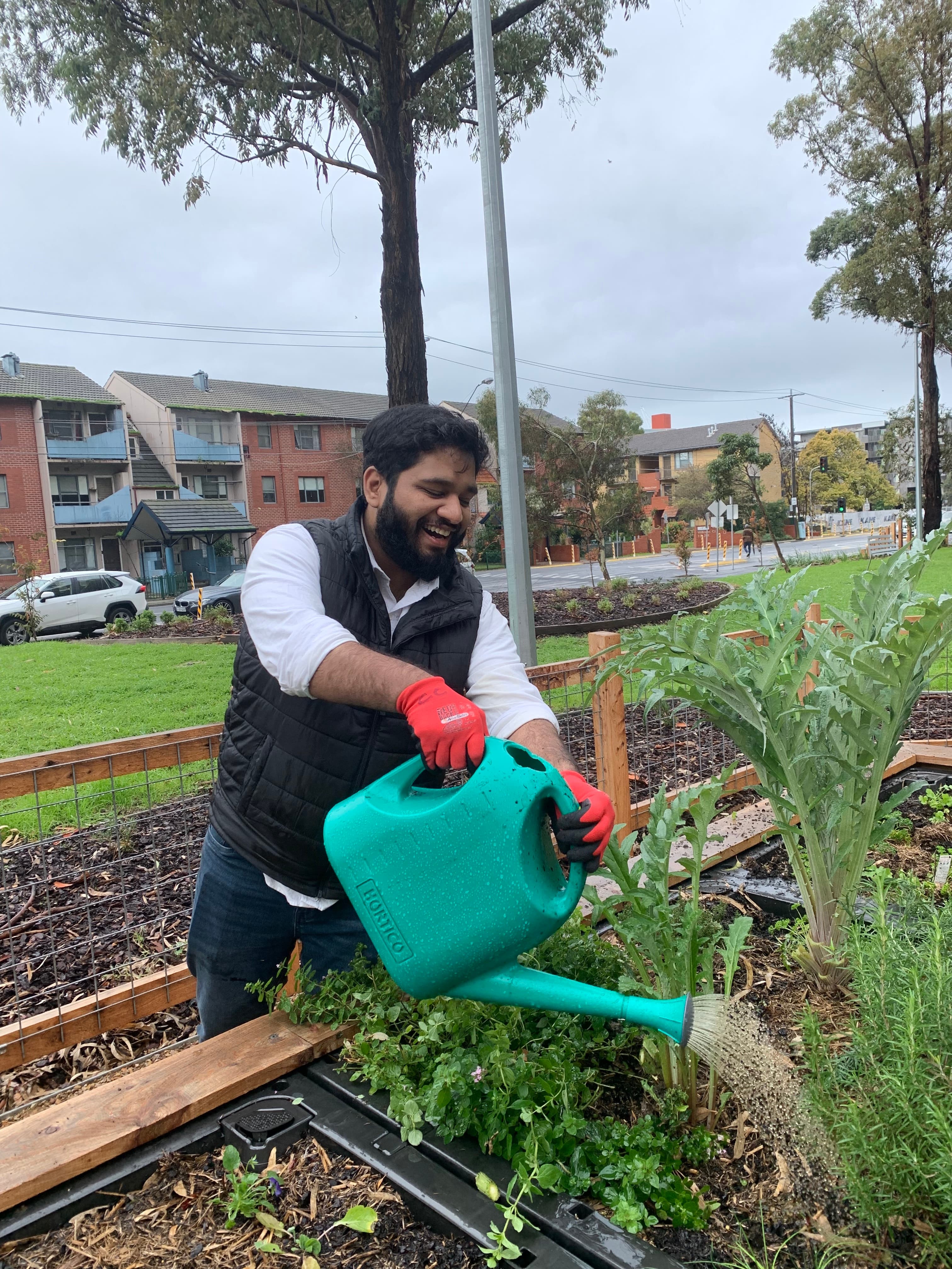 Hatim happily watering the plants at the CC garden