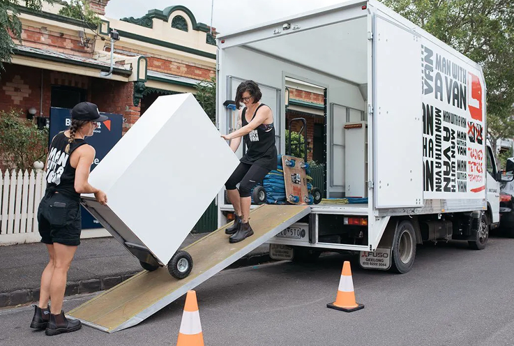 man with a van moving team lifting an item into their moving truck