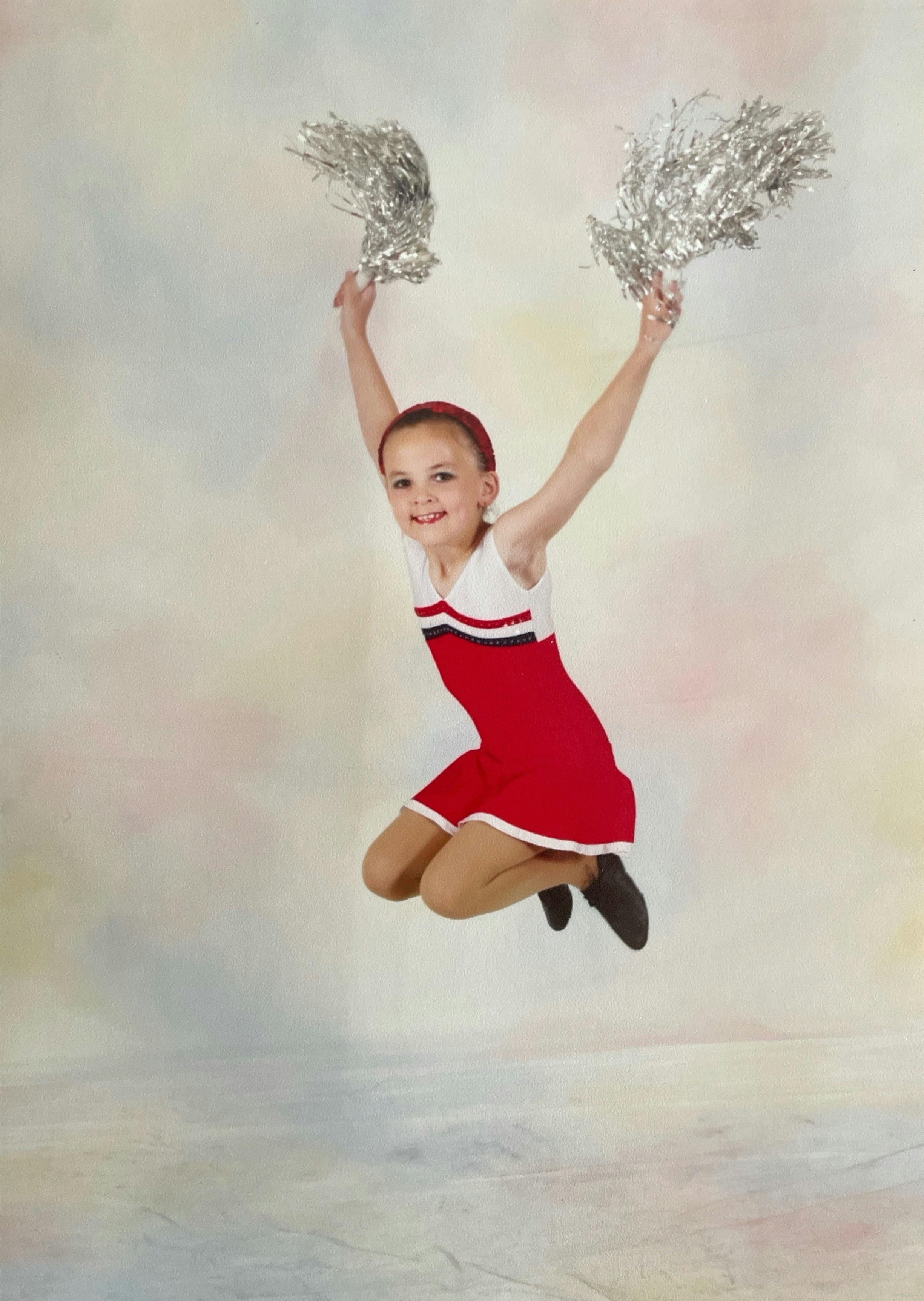 Young Isabelle jumping for a cheer photoshoot