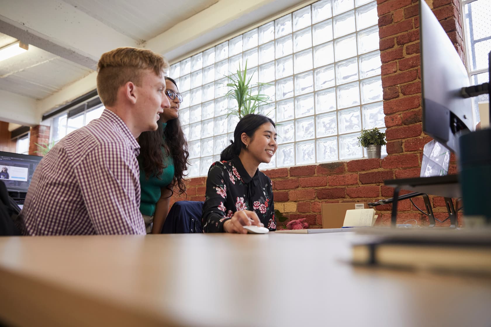 multiple optimising employees gathered around a computer